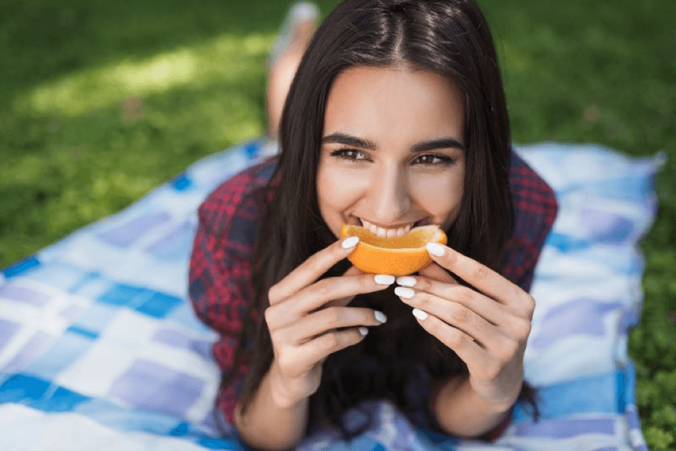 girl eating orange