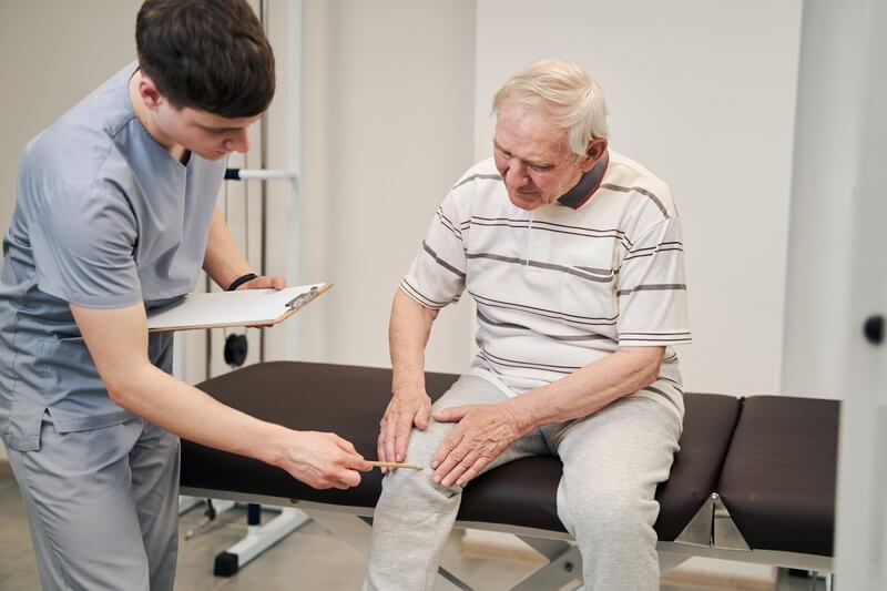 man at doctors with knee problem